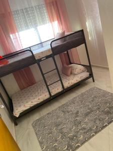 Etagenbett in einem Zimmer mit Fenster in der Unterkunft Mini villa trougout in Al Hoceïma