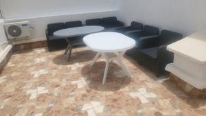 ein Raum mit zwei Tischen und Stühlen und einem Ventilator in der Unterkunft Mini villa trougout in Al Hoceïma + 3 Fotos