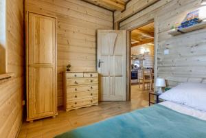 ein Schlafzimmer mit einem Bett und einer Tür zur Küche in der Unterkunft Sielski Spokój Gietrzwałd in Gietrzwałd