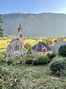 une vieille église avec un clocher dans un champ dans l'établissement La Maison de Montagne, à Valbonnais
