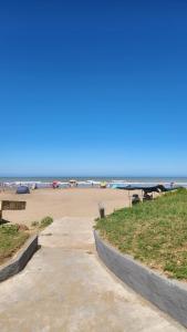 a sandy beach with a picnic table and a bench at Depto 2 ambientes A pasos del MAR in Mar de Ajó