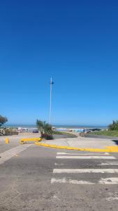 a parking lot with yellow barriers in front of the ocean at Depto 2 ambientes A pasos del MAR in Mar de Ajó +5 photos