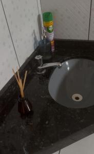 a bathroom sink with chopsticks in a cup next to it at Apto garagem incluso in Marabá