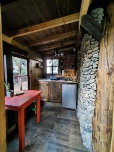 a kitchen with a wooden table and a stone wall at Buen Paso in Icod de los Vinos +9 photos