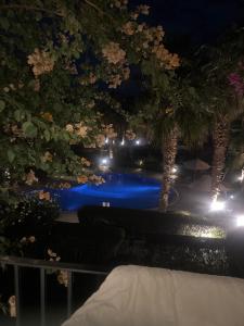 a view of a pool at night with palm trees at Veranda resort in Hurghada