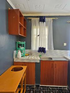 a kitchen with a counter and a sink and a window at ZuriStay in Nakuru +3 photos