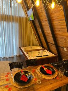 een kamer met een badkuip en twee borden met eten op een tafel bij Chalé Riacho - Cabana em Contenda - Chalé romântico com hidromassagem in Contenda +24 foto's