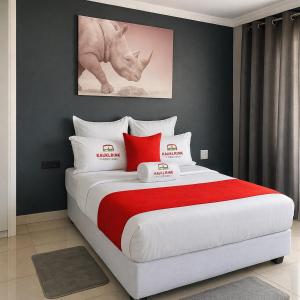 een slaapkamer met een groot bed met rode en witte kussens bij Kangumine Self Catering Units in Okakarara