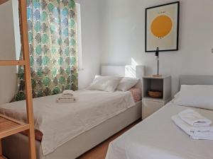 a small bedroom with two beds and a window at Villa Porto in Rogač