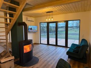 a living room with a wood stove in a house at OAK House domek z balią w Serskim Lesie in Las Dalny
