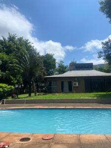 a swimming pool in front of a house at Hazel Nest Ezulwini in Ezulwini