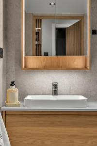 a bathroom with a white sink and a mirror at Unique Tromsø mini-house! in Tromsø