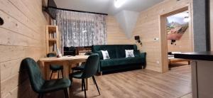 a living room with a green couch and a table at Przy Potocku in Czarna Góra
