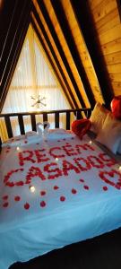 een bed met rode rozen erop in een kamer bij Chalé Riacho - Cabana em Contenda - Chalé romântico com hidromassagem in Contenda