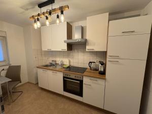 una cucina con mobili bianchi e un frigorifero bianco di Apartment 3 ABG69 - ideal für Familien und Geschäftsreisende a Gera Altre 11 foto