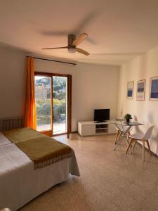 a bedroom with a bed and a television and a table at Apartamentos El Sol in Tossa de Mar