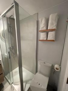 a bathroom with a shower and a toilet and towels at Apartamentos El Sol in Tossa de Mar +49 photos