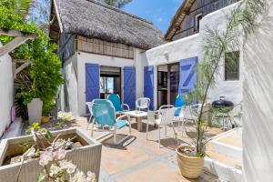 a patio with blue chairs and a table at BlueMoon Villa - Authentic, seaside living in Trou dʼ Eau Douce