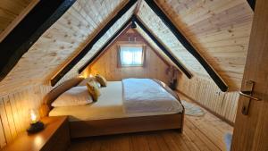 a bedroom with a bed in a wooden attic at Holiday Home BIBA With Heated Outdoor Pool in Gornja Stubica