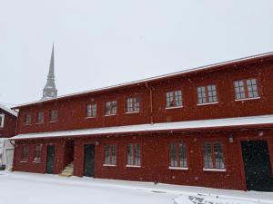 een groot rood bakstenen gebouw met een klokkentoren bij MoraTomten - Stallet in Mora
