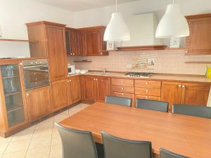 una cucina con mobili in legno, tavolo e sedie in legno di Lyllà a Montecchio Maggiore