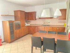 una cucina con armadi in legno e un tavolo in legno con sedie di Lyllà a Montecchio Maggiore