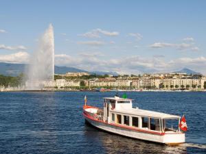 a boat on the water with a fountain in the background at hotelF1 Genève Aéroport Ferney in Ferney-Voltaire