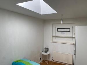 a bedroom with a skylight and a white wall at Motel in Wednesbury