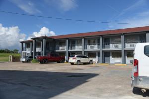 een groot gebouw met auto's geparkeerd op een parkeerplaats bij Royal Inn in Port Arthur