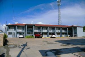 een groot gebouw met auto's geparkeerd op een parkeerplaats bij Royal Inn in Port Arthur