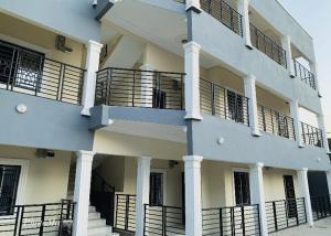 a white building with white columns and balconies at Nova apartments in Amdalai