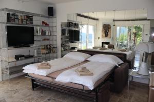 two beds in a room with a tv and a living room at Casa Bellavista Rovio in Rovio