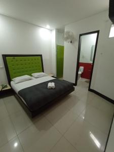 ein Schlafzimmer mit einem großen Bett und einem Spiegel in der Unterkunft Hotel Spa Laureles in Medellín