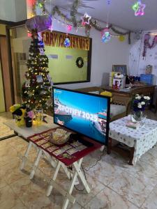 una televisione appoggiata su un tavolo davanti a un albero di Natale di เอินอพาร์ตเมนต์ a Ban Phae Buak Ha