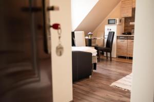 a living room with a bed and a kitchen at Centrum Apartman in Nagykálló +23 photos