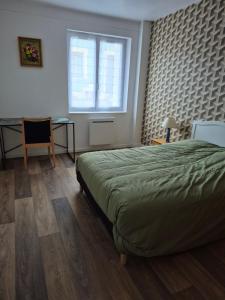 een slaapkamer met een bed, een raam en een bureau bij Le break en nord Cotentin in Cherbourg en Cotentin