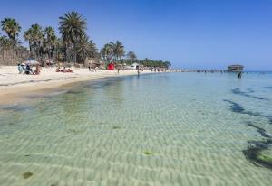 a beach with a group of people in the water at Dar Hkaïem in Hammam Sousse