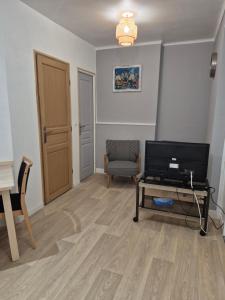een woonkamer met een televisie en een stoel bij Le break en nord Cotentin in Cherbourg en Cotentin +5 foto's