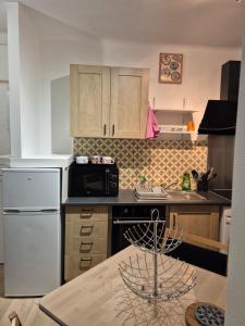 een keuken met een witte koelkast en een magnetron bij Le break en nord Cotentin in Cherbourg en Cotentin