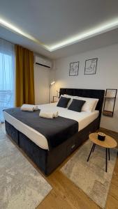 a bedroom with a large bed and a table at Skyline Panorama in Vrnjačka Banja +27 photos