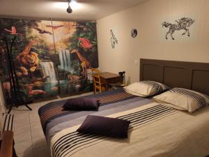 a bedroom with two beds and a painting on the wall at la ferme des bigornes in Châtillon-sur-Indre