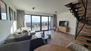 a living room with a couch and a large window at BeskidView Meszna 1 in Meszna
