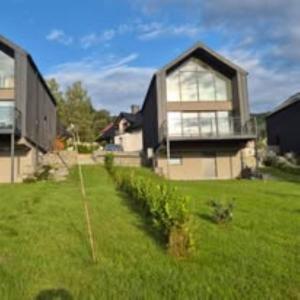 a house in a field of green grass at BeskidView Meszna 1 in Meszna