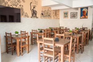a restaurant with wooden tables and chairs and a tv at Hotel Dallas Toríbio in Bom Jesus da Lapa