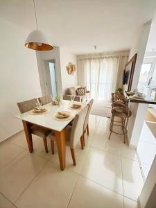 een eetkamer en woonkamer met een tafel en stoelen bij Apto 2 Quartos com AR, Piscina e Varanda Pertinho da Praia de Aruana in Aracaju