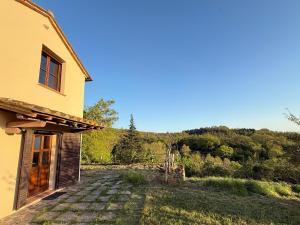 a house with a pathway next to a building at Podere Boschetto Moroni in Massa Marittima