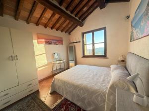 a bedroom with a bed and a desk and a window at Podere Boschetto Moroni in Massa Marittima