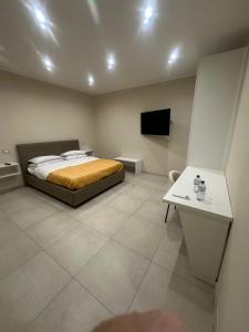 a bedroom with a bed and a table and a tv at Souad 2 in San Prisco