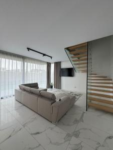 een woonkamer met een bank en een trap bij KNIGHT Resort in Voluntari +13 foto's