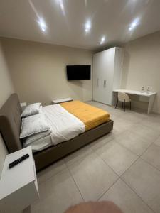 a bedroom with a bed and a desk and a television at Souad 2 in San Prisco